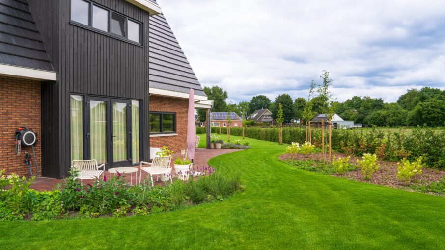 Landelijke tuin met terras, kleurrijke borders en een ruim gazon