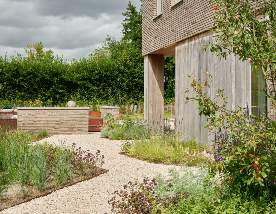 Grindpad met bloemrijke borders en vaste planten richting zwembad