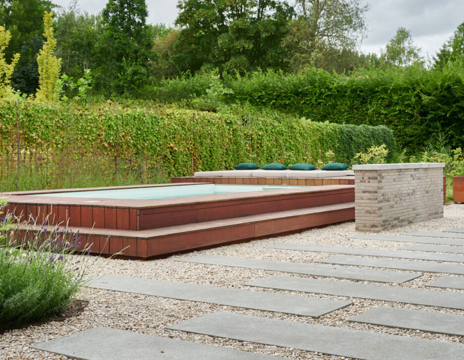 Modern zwembad in weelderige tuin