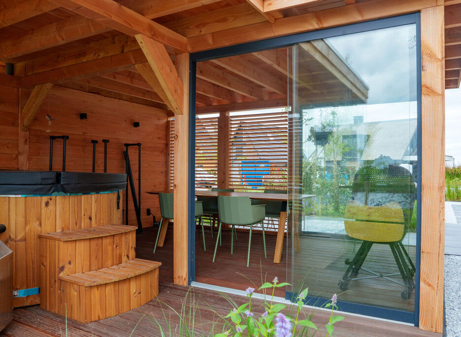 Hoveniers Collectief - Houten overkapping met glaswand Houten overkapping met glazen wand in tuin