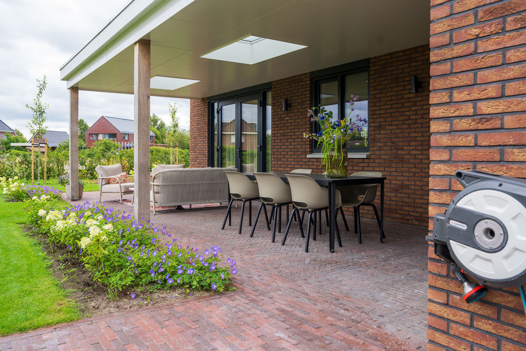 Terras met gebakken waaltjes als sierbestrating in de tuin