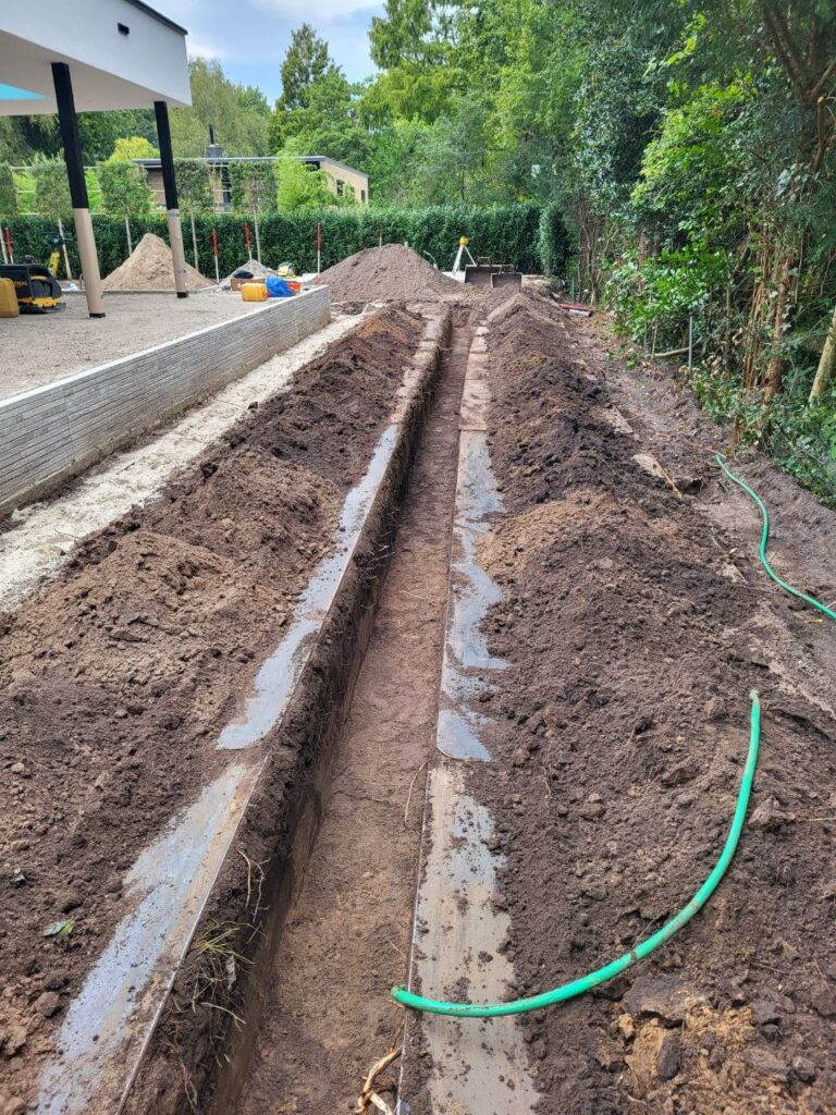 Sleuf graven voor aanleg drainage in de tuin