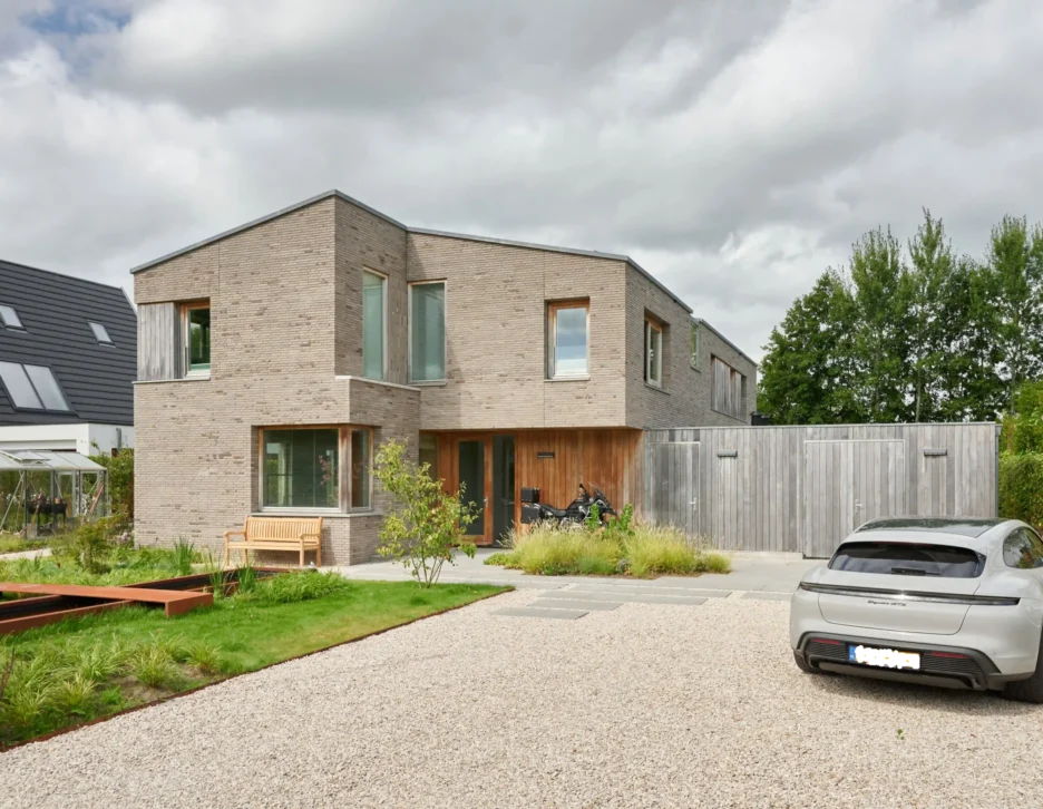 Hoveniers Collectief - Oprit grind met borders en cortens vijver Oprit van grind met kleurrijke borders en cortens vijver in tuin